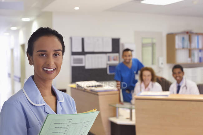 Enfermera sonriendo en el moderno pasillo del hospital - foto de stock