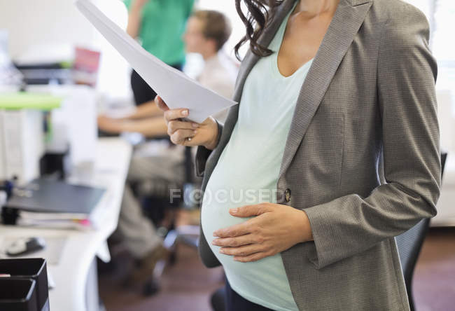 Беременная деловая женщина, работающая в офисе — стоковое фото