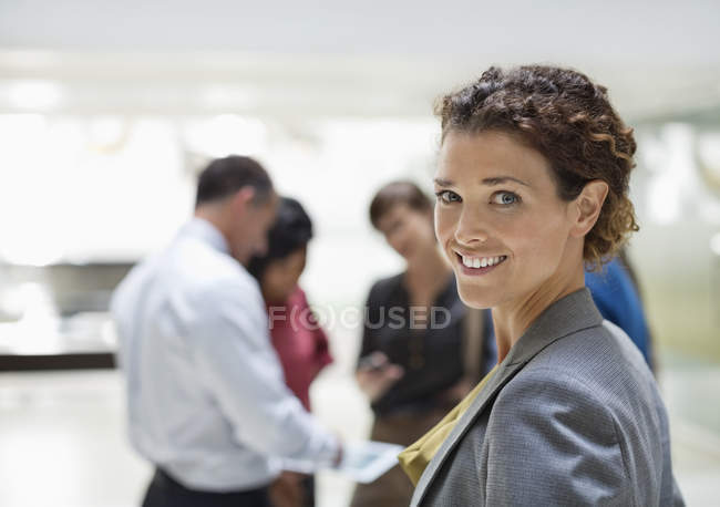 Caucasienne femme d'affaires souriant au bureau moderne — Photo de stock