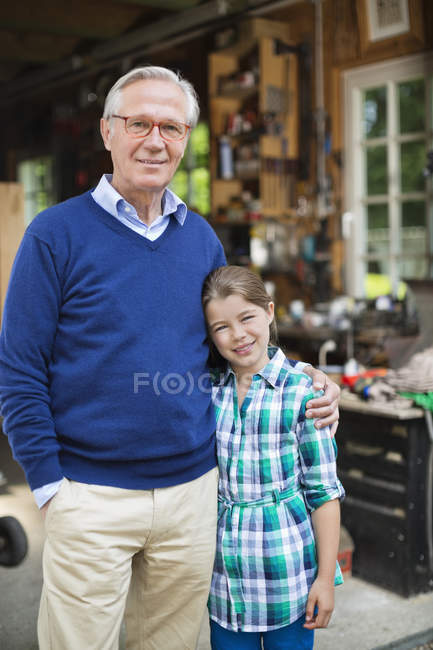 Homem e neta sorrindo na garagem — Fotografia de Stock
