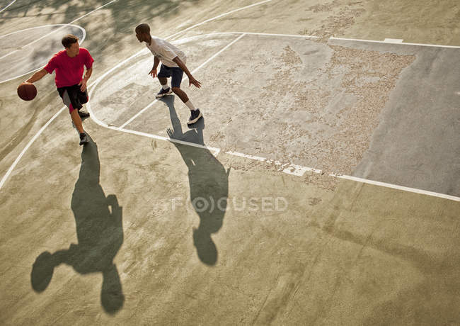 Мужчины играют в баскетбол на площадке — стоковое фото