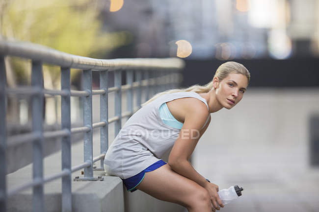 Женщина отдыхает после тренировки на городской улице — стоковое фото