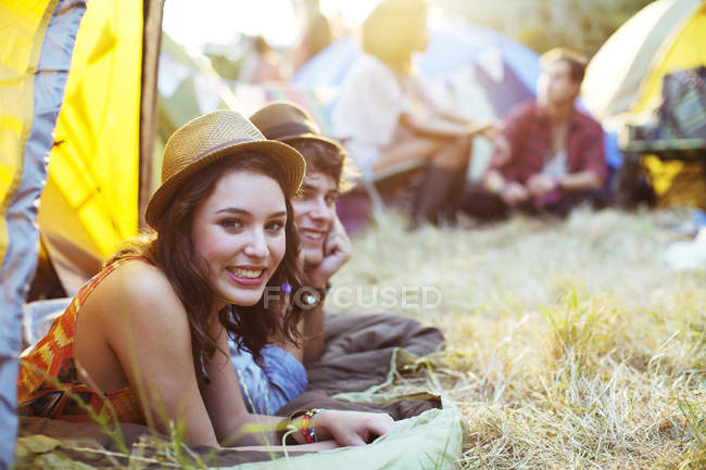Portrait of couple laying in tent at music festival — Stock Photo