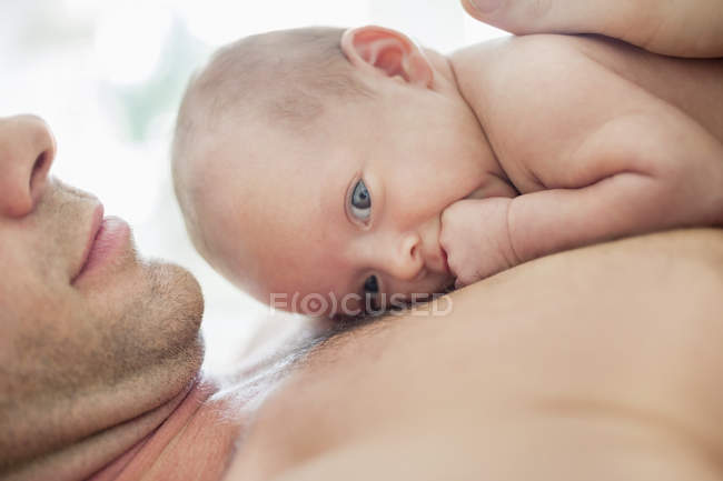 Отец колыбельной новорожденного ребенка на груди — стоковое фото