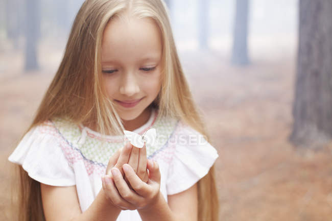 Close up of girl holding butterfly in woods — Stock Photo