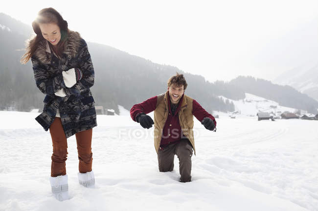 Happy couple walking through deep snow in field — Stock Photo