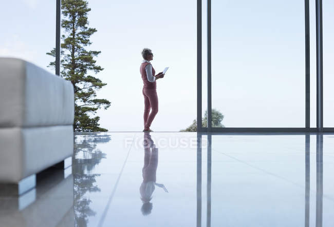 Reflection of businesswoman on modern office floor — Stock Photo