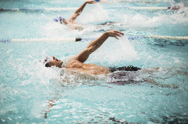 Nadadores correndo na água da piscina — Fotografia de Stock