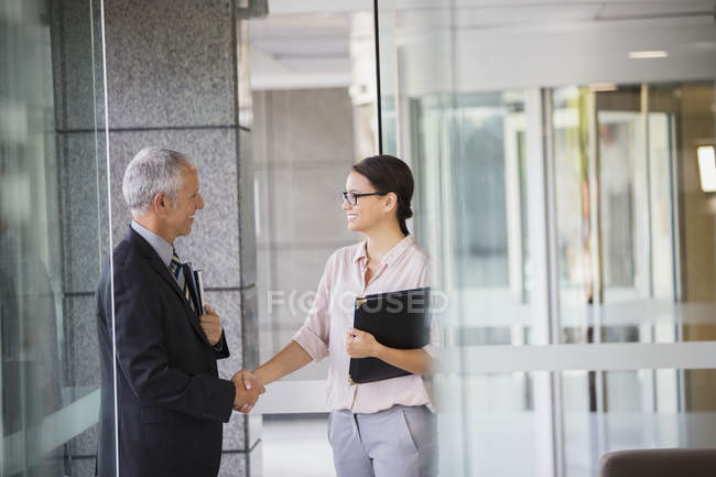 Geschäftsleute beim Händeschütteln im Bürogebäude — Stockfoto
