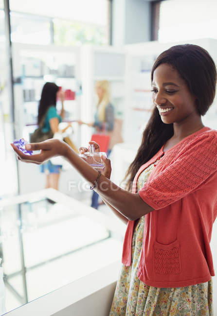 Woman trying out perfume in drugstore — Stock Photo