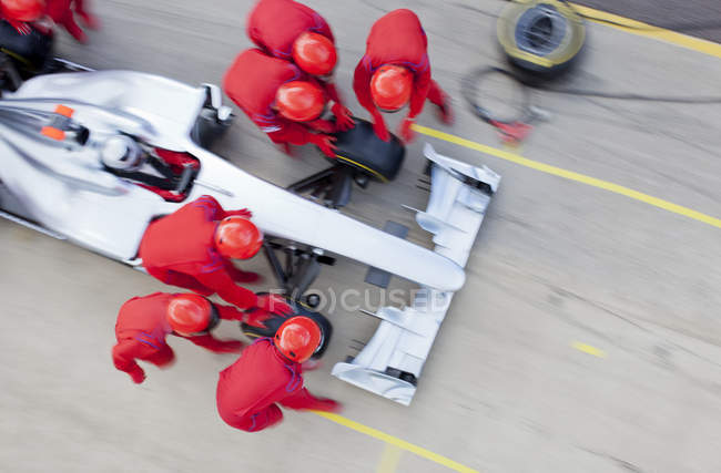 Equipo de carreras trabajando en pit stop - foto de stock