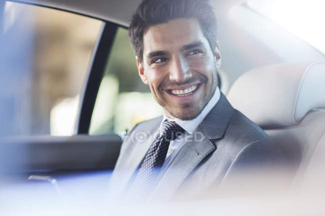 Hombre de negocios sonriente sentado en el coche - foto de stock