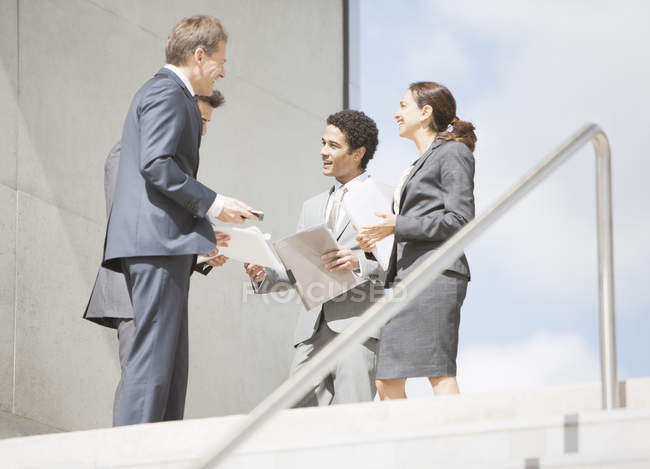 Geschäftsleute mit Papierkram treffen sich oben auf der Treppe — Stockfoto