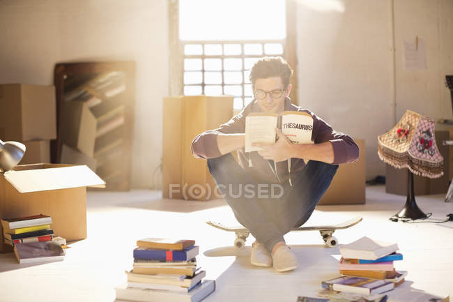 Jovem homem lendo em nova casa — Fotografia de Stock