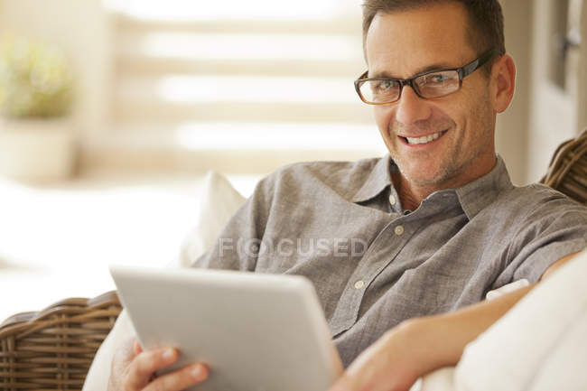 Retrato del hombre sonriente usando tableta digital - foto de stock