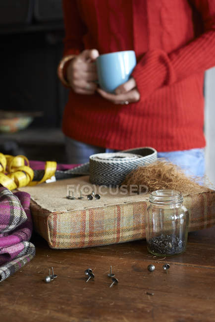 Mujer tomando una taza de café y elaborando - foto de stock