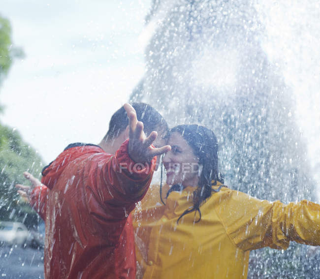 Happy caucasian couple dancing in rain — Stock Photo