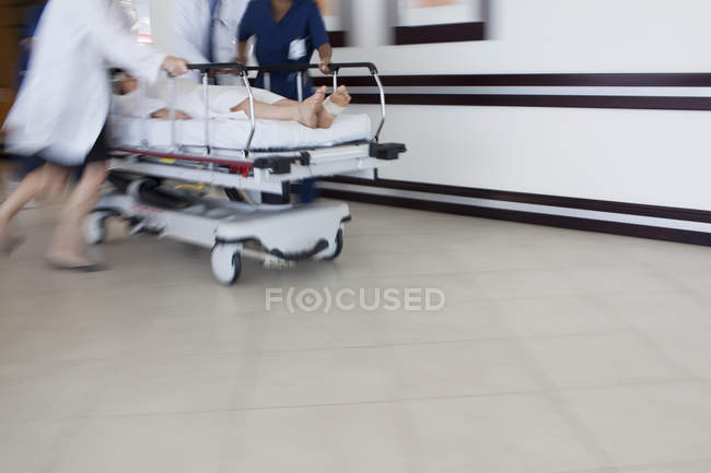 Обрезанное изображение персонала больницы, спешащего в операционную — стоковое фото