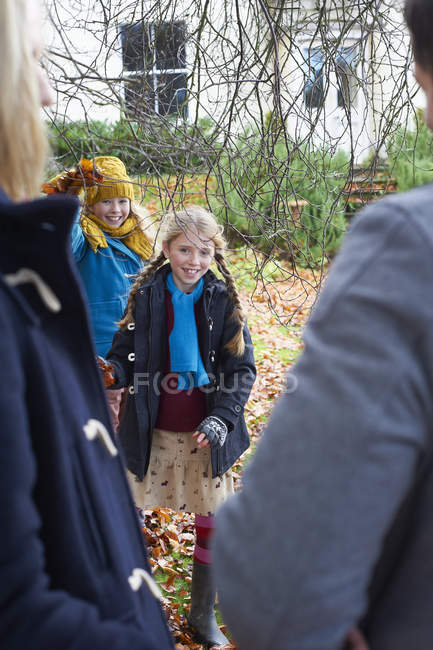 Chicas sonrientes caminando hacia los padres - foto de stock