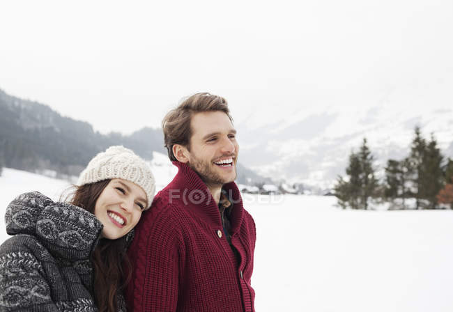 Glückliches Paar im verschneiten Feld — Stockfoto