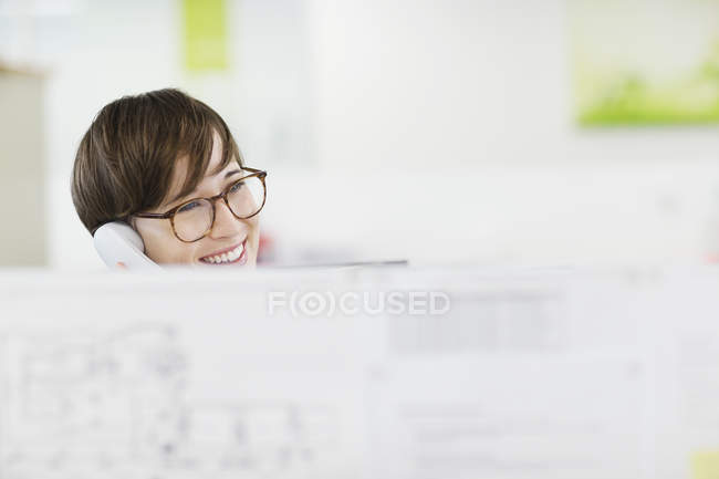 Businesswoman talking on phone at desk at modern office — Stock Photo