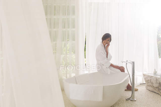 Женщина работает ванна в современной ванной комнате — стоковое фото