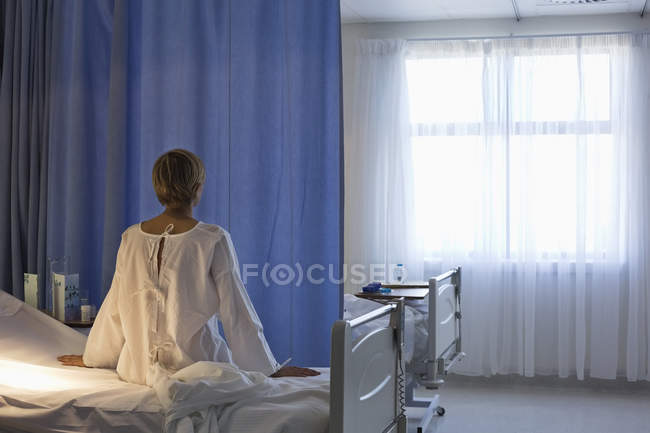 Rückansicht des Patienten im Mantel auf dem Krankenhausbett — Stockfoto