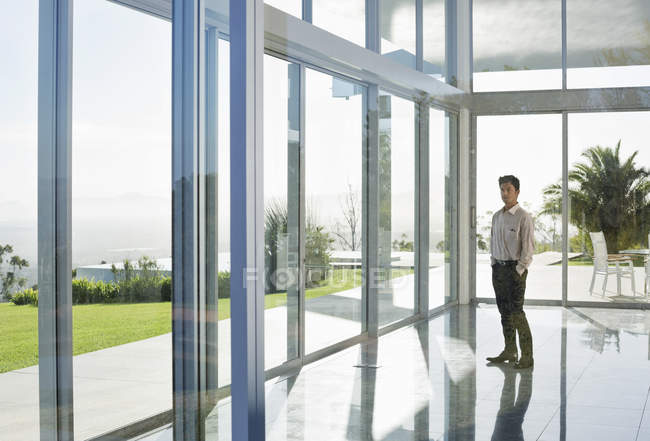 Азіатський бізнесмен стоїть в сучасному офісі — стокове фото