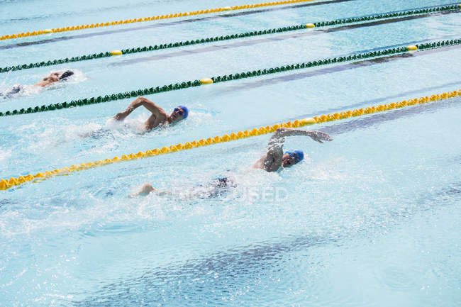 Swimmers racing in pool water — Stock Photo