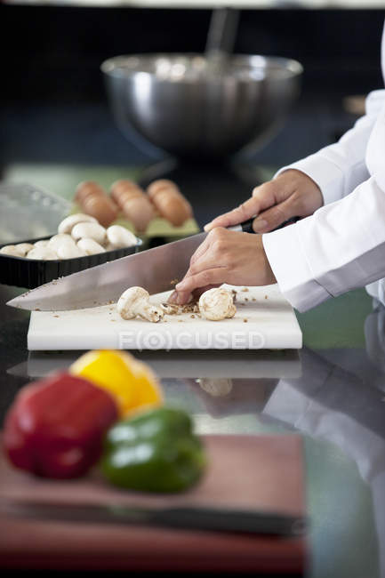 Chef picando verduras en la cocina del restaurante - foto de stock