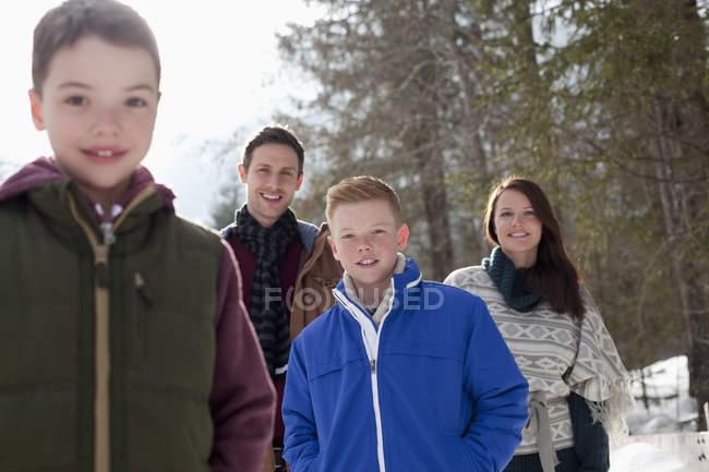 Retrato de familia sonriente en bosques nevados - foto de stock