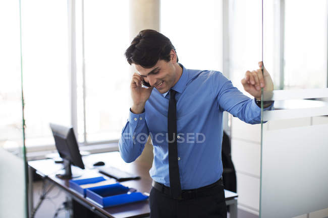 Empresario hablando por celular en la oficina - foto de stock