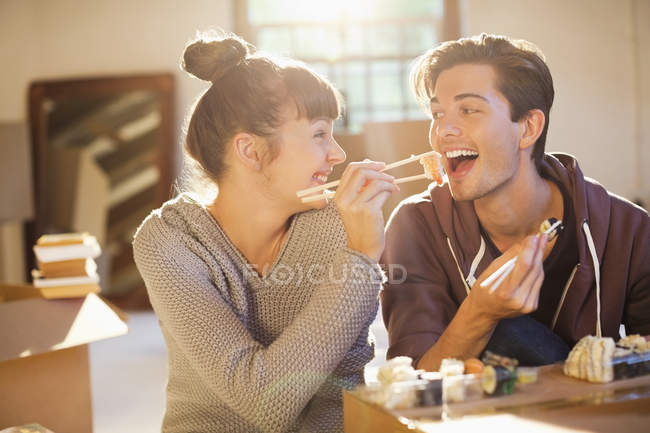 Casal comer sushi juntos em nova casa — Fotografia de Stock