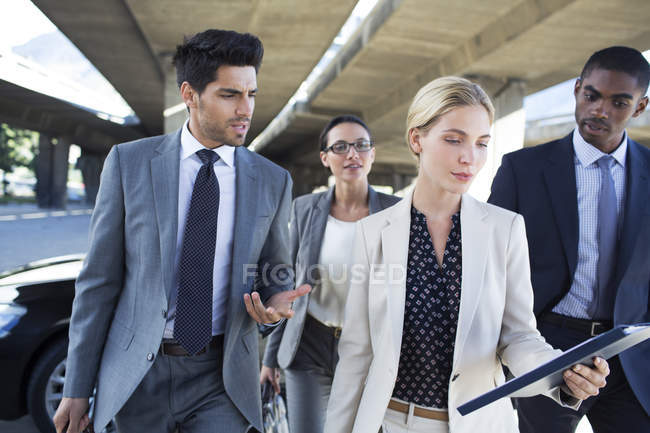 Business people walking under city overpass — Stock Photo