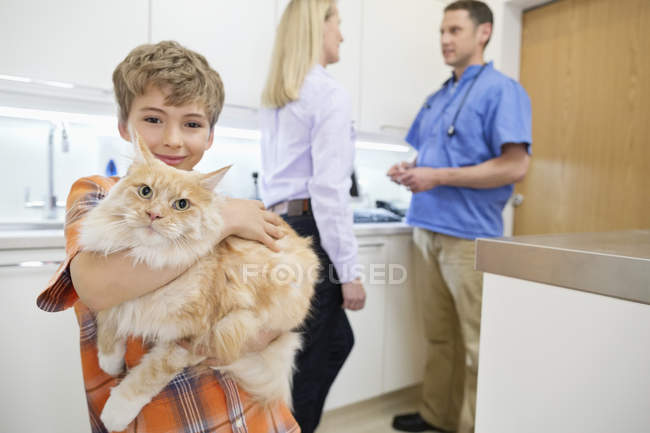 Caucasian owner boy holding cat in veterinary surgery — Stock Photo
