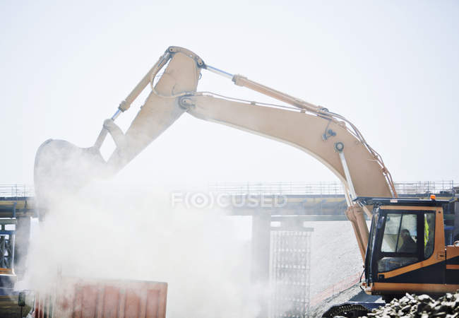 Bagger arbeitet tagsüber auf Baustelle — Stockfoto