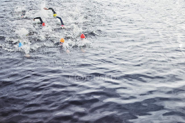 Triathlètes confiants et forts éclaboussures dans l'eau — Photo de stock