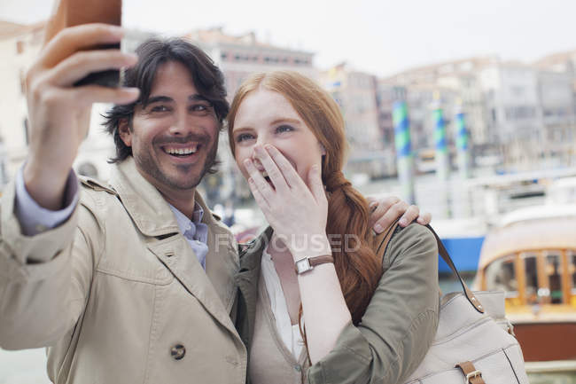 Смеющаяся пара делает автопортрет с фотоаппаратом в Венеции — стоковое фото
