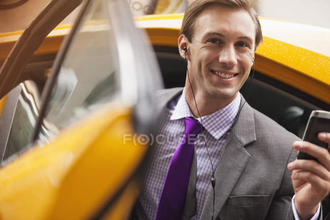 Businessman climbing out of taxi — Stock Photo