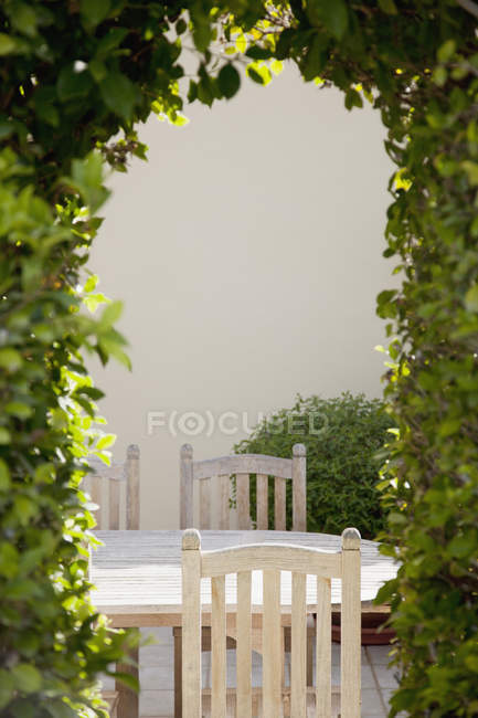 View of patio table through vine-covered pergola — Stock Photo