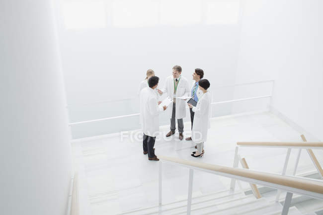 Doctors meeting on landing of stairs — Stock Photo