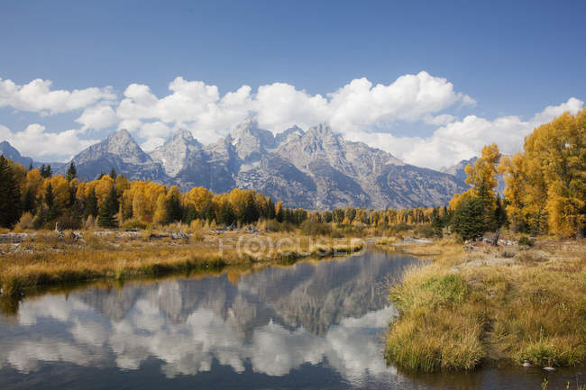 Mountains and landscape reflected in still river — Stock Photo