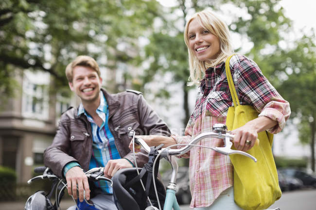 Couple debout sur des vélos dans la rue de la ville — Photo de stock