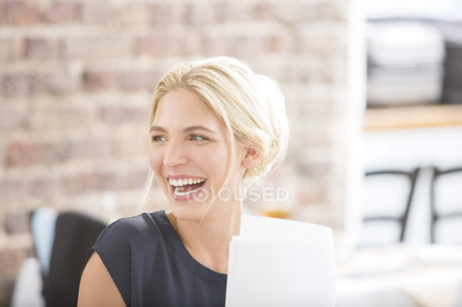 Жінка сміється в офісі — стокове фото