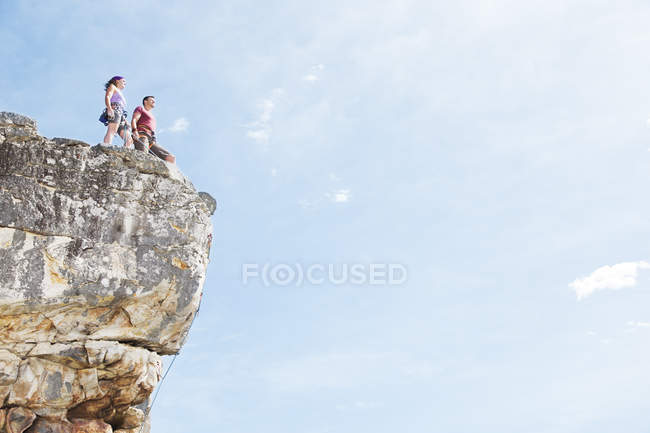 Caucasian couple of climbers standing on rocky hilltop — Stock Photo