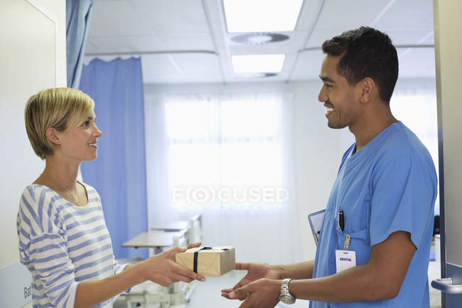 Patient giving nurse gift in hospital — Stock Photo