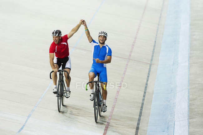 Велогонщики, празднующие на велодроме — стоковое фото