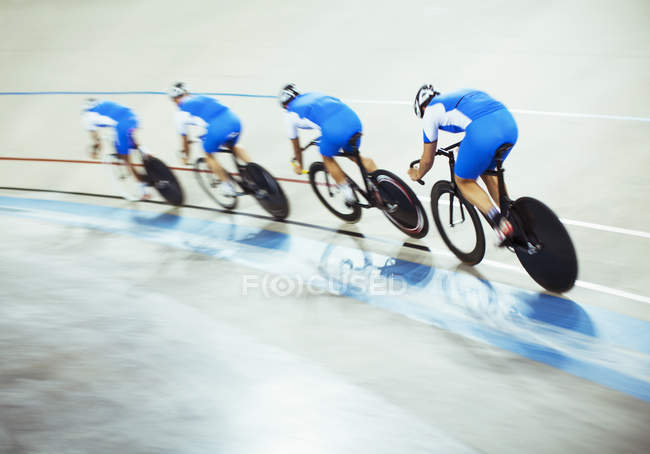 Equipo de ciclismo de pista que monta alrededor de velódromo - foto de stock