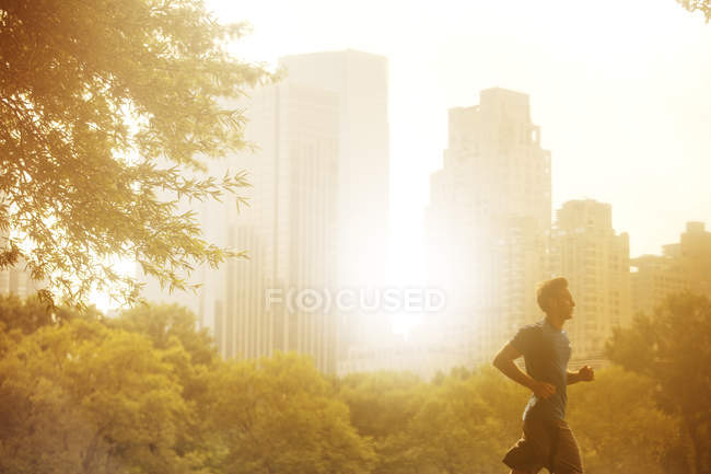 Hombre corriendo en parque urbano - foto de stock