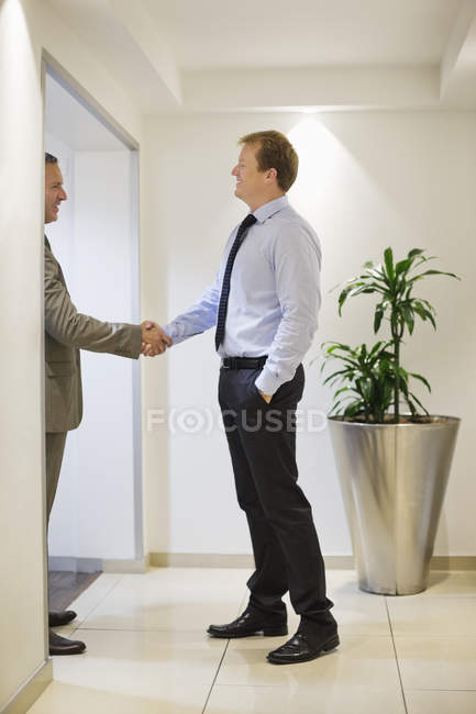 Бізнесмени тремтять руками в сучасному офісі — стокове фото